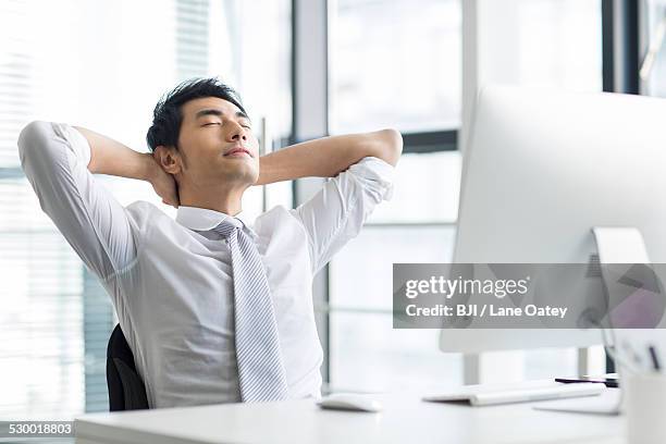 young businessman resting in office - sitting chair office relax stock pictures, royalty-free photos & images