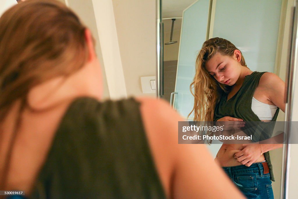 Young Woman pinching her waist