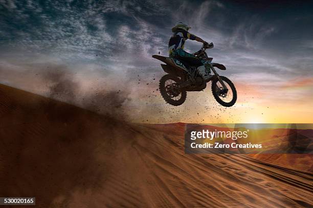 young male motocross racer jumping mid air at sunset - motocross stock photos et images de collection