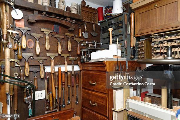 selection of tools and equipment in traditional bookbinding workshop - reliure de livre photos et images de collection