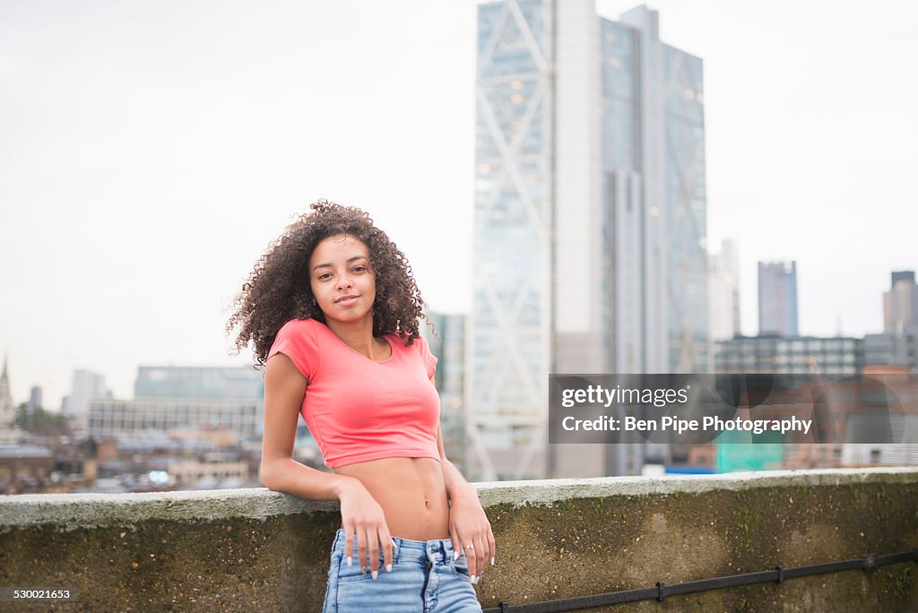 Young woman leaning against wall