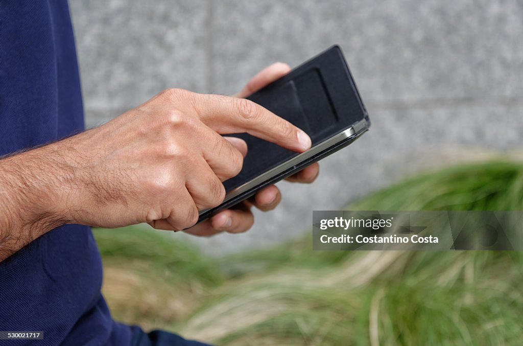 Man using smartphone, focus on smartphone