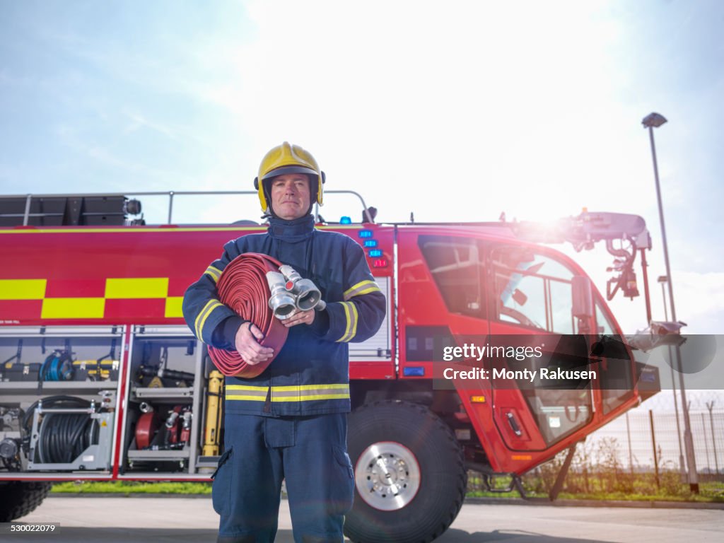 Portrait of fireman in front of fire engine in airport fire station