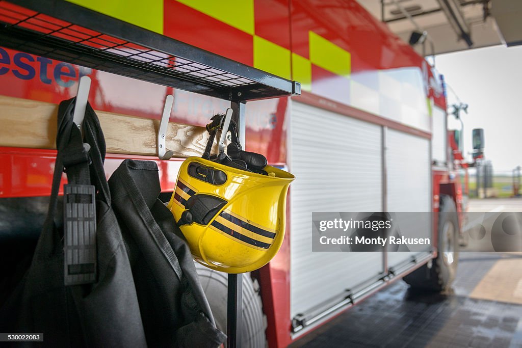 Firemans helmet hanging by fire engine in fire station