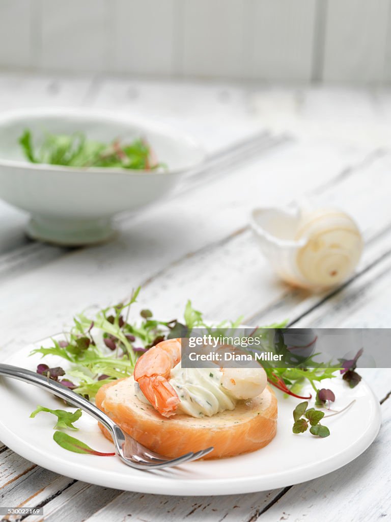 Plate of seafood with mixed green leaf micro salad and baby chard