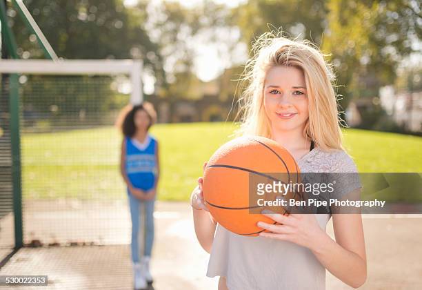 portrait of young woman holding up basketball - bethnal green fotografías e imágenes de stock