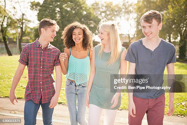 four young adult friends strolling in park - bethnal green fotografías e imágenes de stock