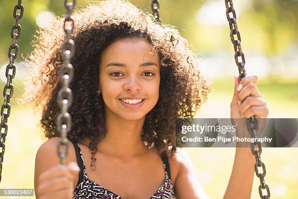 close up portrait of young woman sitting on park swing - bethnal green fotografías e imágenes de stock