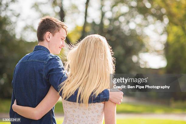 rear view of romantic young couple strolling in park - bethnal green fotografías e imágenes de stock