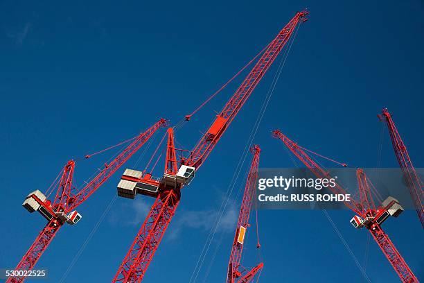 red construction cranes - grue photos et images de collection