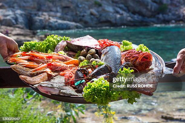 hand of waitress and waiter with fresh seafood platter, mallorca, spain - seafood platter stockfoto's en -beelden