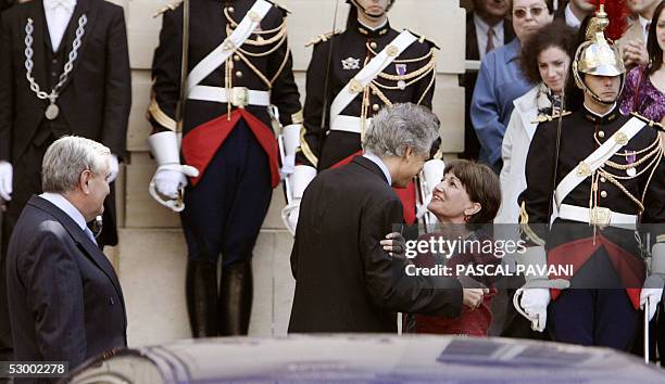 Former French Prime Minister Jean-Pierre Raffarin watches his successor Dominique de Villepin kiss his wife Anne-Marie as they leave Matignon, the...