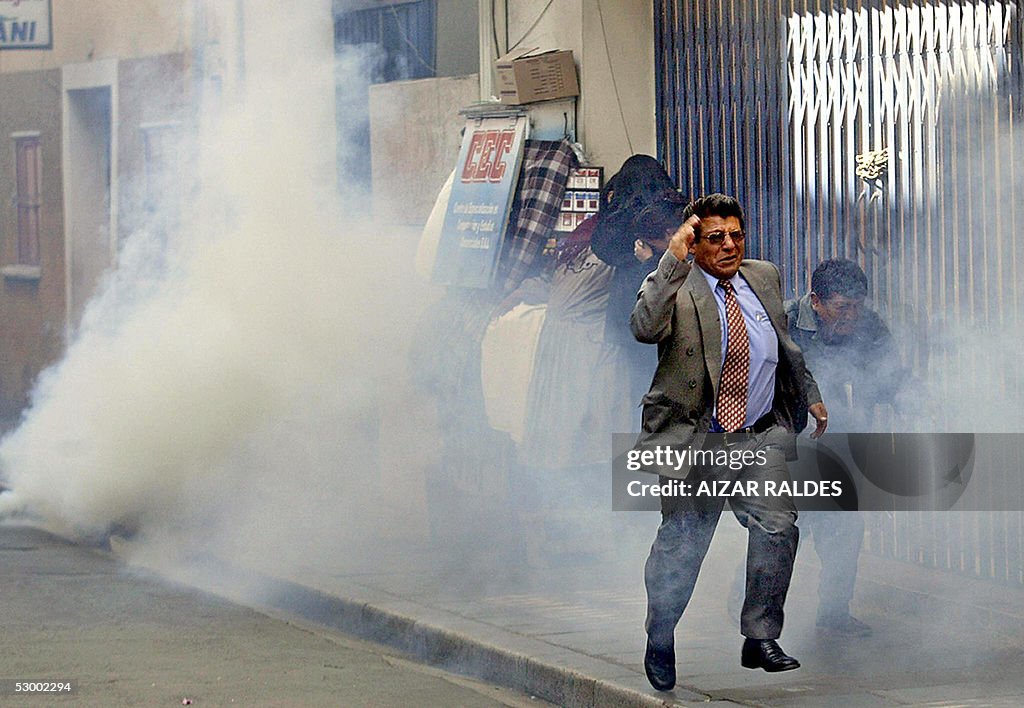 People rush off during clashes with riot forces during a protest in ...