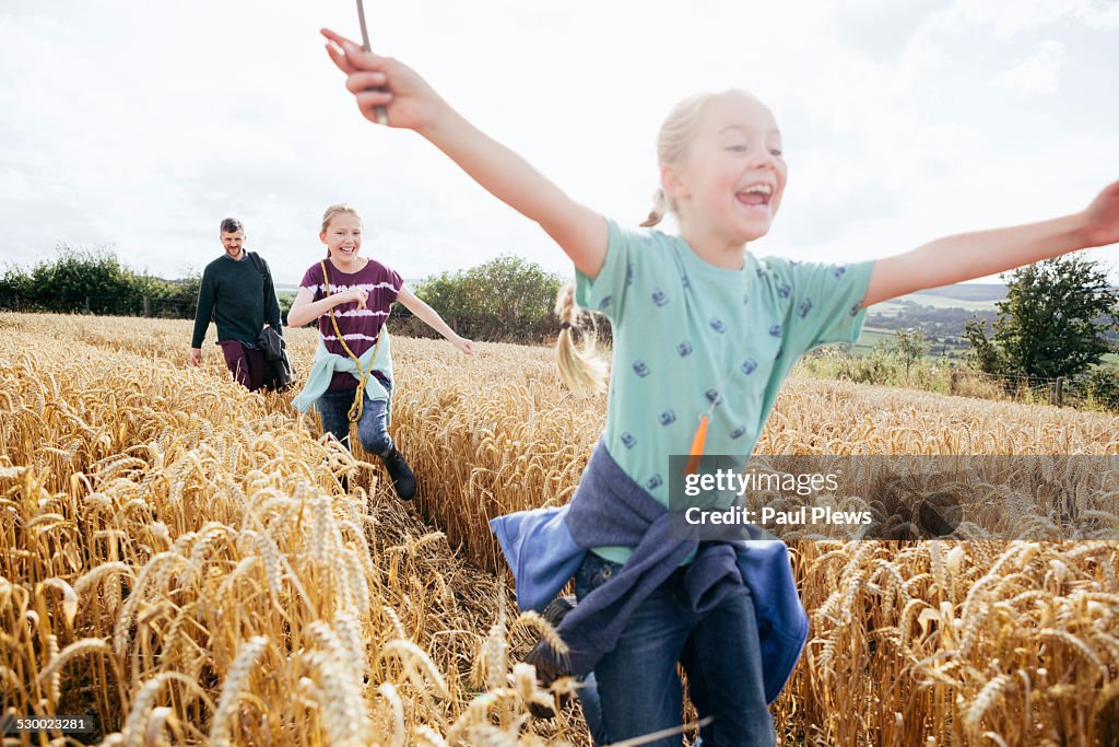 Girl running through field with arms out