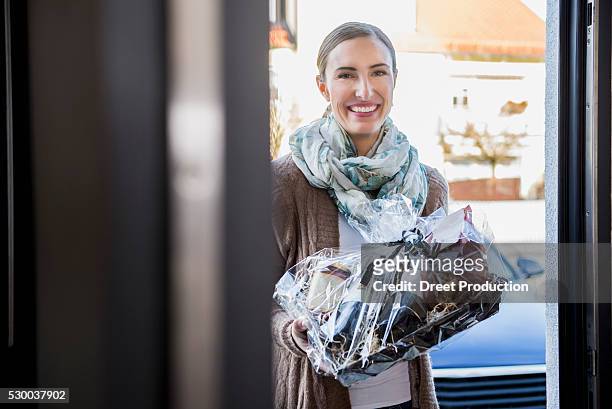 woman presented with a gift to the front door of a friend, munich, bavaria, germany - welcoming guests foto e immagini stock