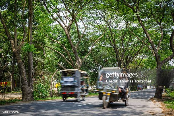 Savar, Bangladesh Tuk-tuks meet on a country road on April 13, 2016 in Savar, Bangladesh.