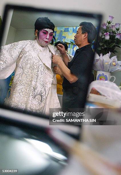 Chan Gum-to , Cantonese opera performer and instructor, demonstrates how to put on proper costumes for his students in Hong Kong, 21 May 2005. Chan...