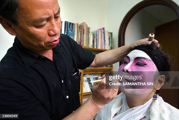 Chan Gum-to , Cantonese opera performer and instructor, demonstrates how to apply performance make-up for his student in Hong Kong, 21 May 2005. Chan...