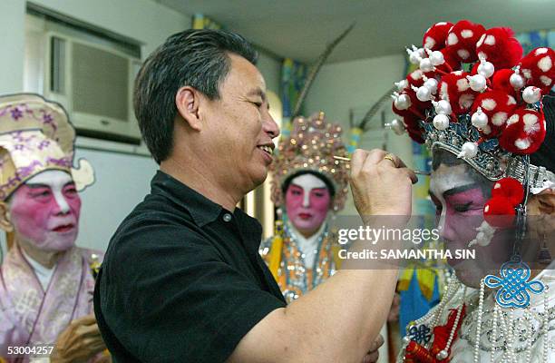 Chan Gum-to , Cantonese opera performer and instructor, helps his students put on make up and traditional costumes in Hong Kong, 21 May 2005. Chan...