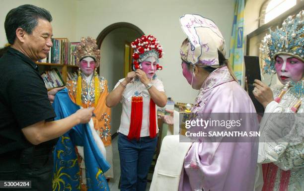 Chan Gum-to , Cantonese opera performer and instructor, helps his students put on traditional costumes in Hong Kong, 21 May 2005. Chan has been given...