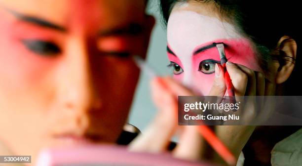 Chinese students paint their faces in preparation for a performance of the Peking Opera during the annual celebration for the International...