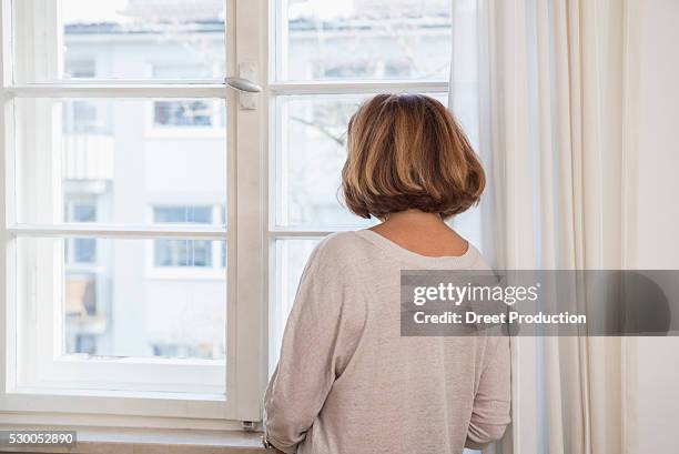 rear view of senior woman looking through a window, munich, bavaria, germany - back view bildbanksfoton och bilder