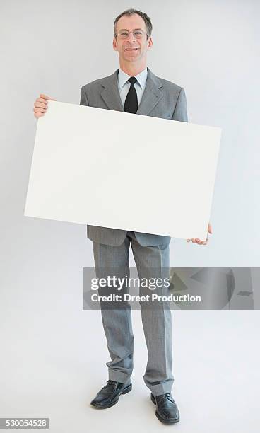 portrait of mature man holding blank whiteboard, smiling - holding poster stock pictures, royalty-free photos & images