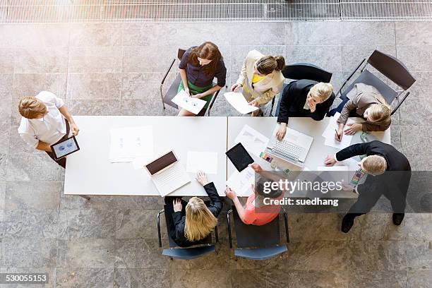 overhead view of business team meeting at desk in office - office space elevated view stock pictures, royalty-free photos & images