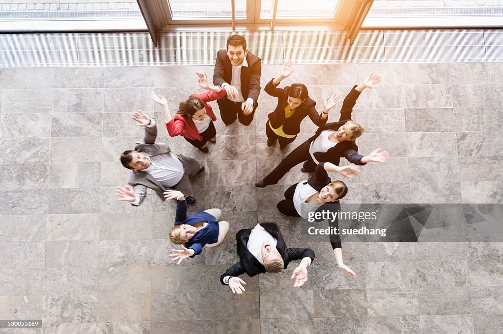 Overhead view of business team in circle jumping for joy