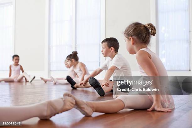 children sitting on floor practicing ballet position in ballet school - ballet boy foto e immagini stock