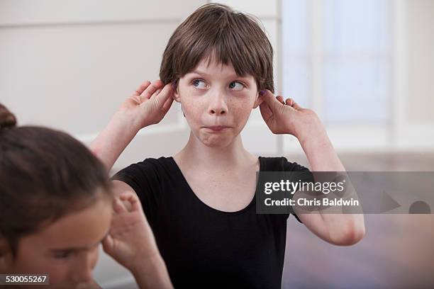 girl with holding ears pulling a face in ballet school - pulling ear stock pictures, royalty-free photos & images