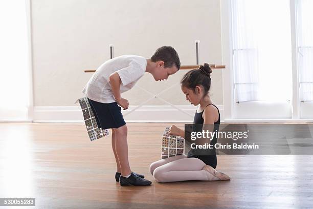 boy and girl swapping stickers in ballet school - boys wearing tights stock-fotos und bilder