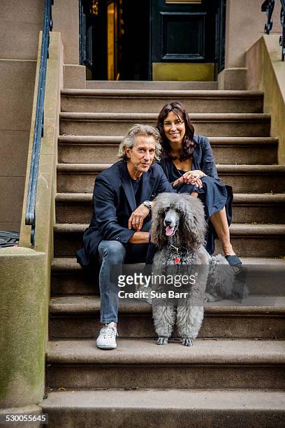 portrait of mature couple and their poodle sitting on apartment stairway - portrait woman looking at camera brave stock-fotos und bilder