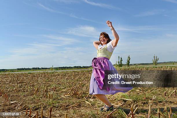 mature woman dancing in field, bavaria, germany - bauer bayern stock-fotos und bilder