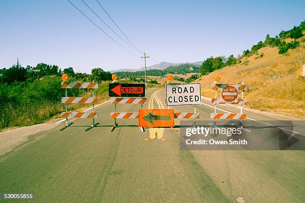 a row of road closed signs across highway - señal de calle sin salida fotografías e imágenes de stock