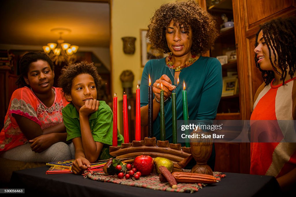 Family lighting kinara candles, celebrating Kwanzaa