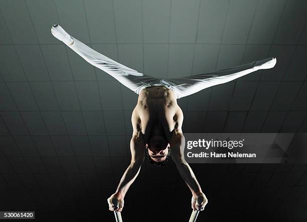 gymnast on parallel bars - male gymnast stock pictures, royalty-free photos & images