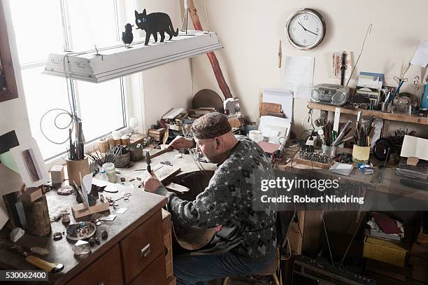 senior male jeweler hitting punches in workshop, bavaria, germany - punching clock stock pictures, royalty-free photos & images