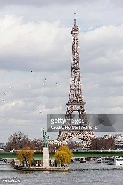 replica of statue of liberty near pont grenelle with eiffel tower in background, paris, france - paris island stock pictures, royalty-free photos & images