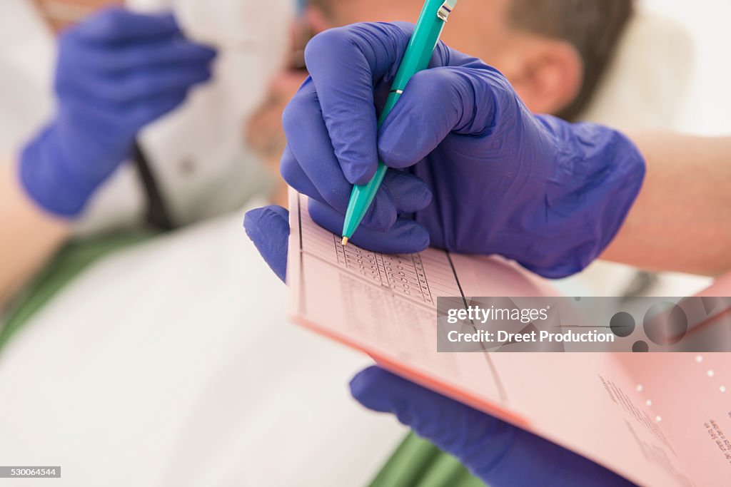 Dental assistant writing on index card, Munich, Bavaria, Germany