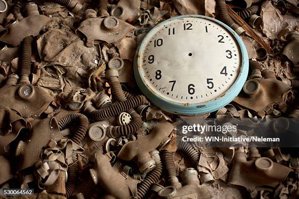 close-up of a clock on the heap of gas masks, - fallout nucleare foto e immagini stock