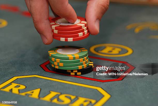 person's hand picking up gambling chips from a table, kiev, ukraine - gambling chip stock pictures, royalty-free photos & images