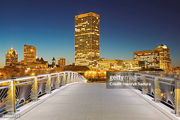 usa, wisconsin, milwaukee, pedestrian bridge with skyline in background - milwaukee wisconsin foto e immagini stock