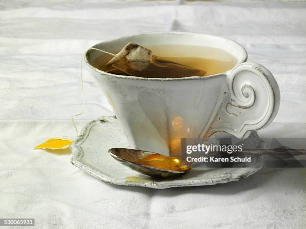 antique teacup on table - theelepel stockfoto's en -beelden