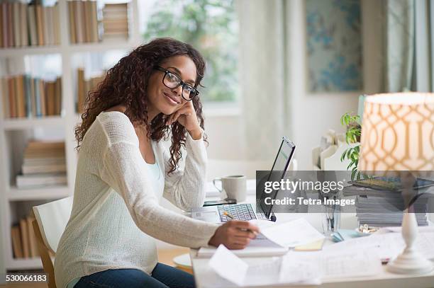 usa, new jersey, jersey city, woman using laptop in home office - african american woman with money stock-fotos und bilder