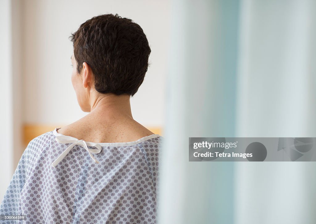 USA, New Jersey, Jersey City, Rear view of senior woman wearing hospital gown