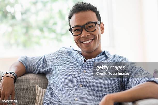 usa, new jersey, jersey city, portrait of young relaxed man smiling - hipster brille stock-fotos und bilder