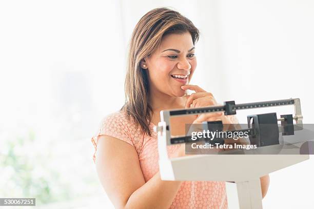 usa, new jersey, jersey city, happy woman standing on scale - happiness scale stock pictures, royalty-free photos & images