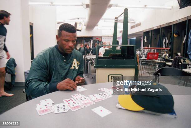 Rickey Henderson of the Oakland Athletics plays solitaire before the game against the Boston Red Sox at Oakland-Alameda Coliseum on April 1, 1998 in...