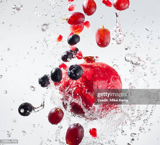 droplets splashing on fruits - freeze motion stock-fotos und bilder